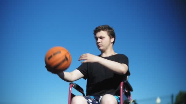 無効に男オープンエアの彼の車椅子からバスケット ボールを果たしています。 — ストック動画