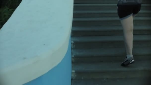 Товста дівчина біжить, щоб піднятися по сходах — стокове відео