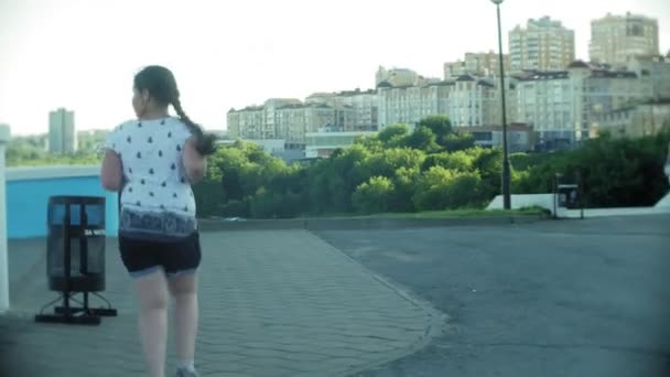 Ένα λίπος κορίτσι που τρέχει γύρω από να ανεβείτε τις σκάλες — Αρχείο Βίντεο