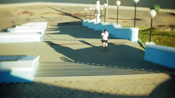 Товста дівчина біжить, щоб піднятися по сходах — стокове відео