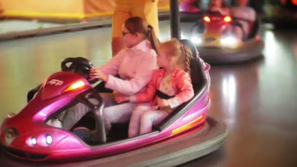 Niños que viajan en el coche de parachoques en el parque de atracciones — Vídeos de Stock