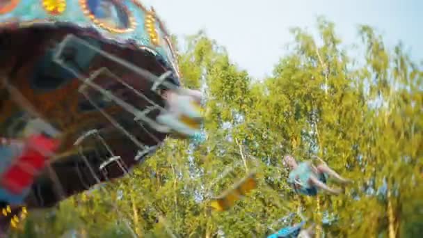 Teenage girls on a chain swing carousel — Stock Video