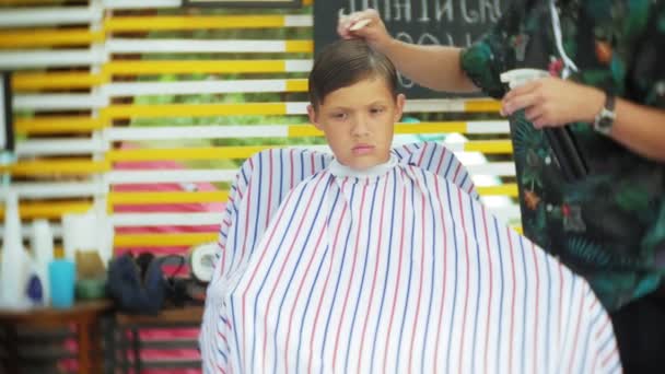 小さな子供が理髪店で散髪を取得. — ストック動画