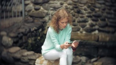 Bir kadın bir akıllı telefon arka duvarına karşı kullanıyor. İçki ve İçecek şarap cam