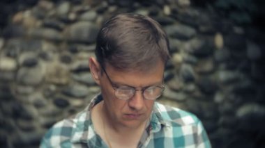 Dizüstü bilgisayar ve belgeleri bir stonewall arka plan üzerinde bir adam duvar işleri ve içecekler şarap cam