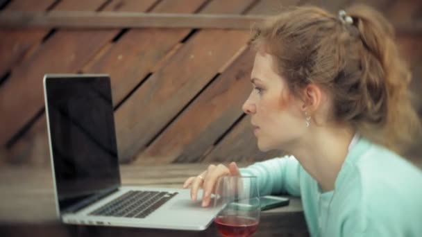 Mujer con laptop y documentos. Bebidas y bebidas vino de una copa — Vídeo de stock