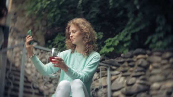 Uma Mulher Está Usando Smartphone Contra Uma Parede Traseira Bebidas — Vídeo de Stock