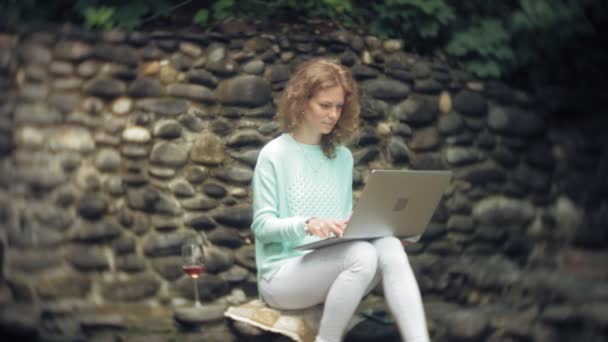 Kobieta z laptopa i dokumenty na tle ściany stonewall — Wideo stockowe