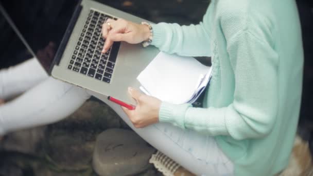 Mulher com laptop e documentos no fundo de uma parede de pedra — Vídeo de Stock