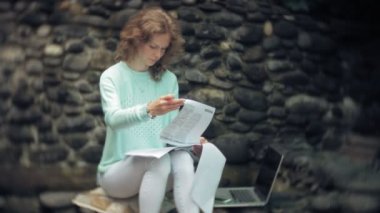 Dizüstü bilgisayar ve belgeleri stonewall duvar arka plan üzerinde kadın ile