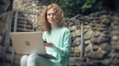 Dizüstü bilgisayar ve belgeleri stonewall duvar arka plan üzerinde kadın ile