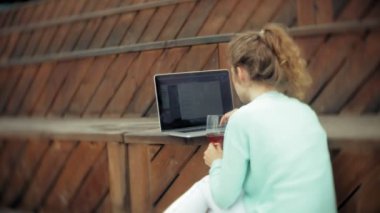 Kadın bir dizüstü bilgisayar ve belgeler. İçki ve İçecek şarap cam