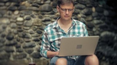 Dizüstü bilgisayar ve belgeleri bir stonewall arka plan üzerinde bir adam duvar işleri ve içecekler şarap cam