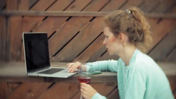 Frau mit Laptop und Dokumenten. Getränke und Wein aus einem Glas — Stockvideo