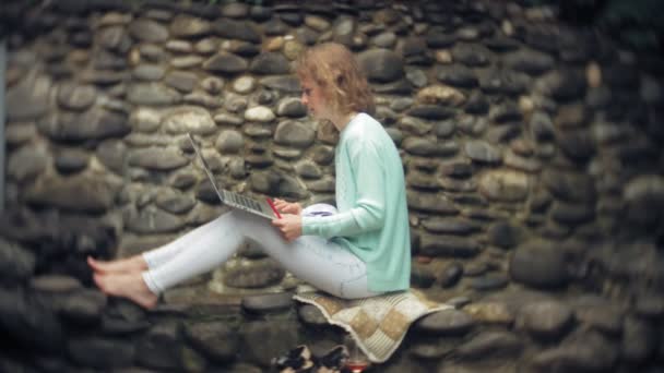 Femme avec ordinateur portable et documents sur le fond d'un mur de pierre — Video
