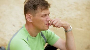 Vape kum plajındaki olgun adam dumanlar