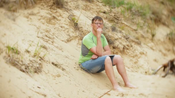 Mogen man på en sandstrand röker vape — Stockvideo