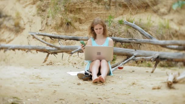 Zajęty piękna młoda kobieta pracę na komputerze przenośnym z dokumentacją firmy zbierając telefon do pracy wywołanie siedzi na plaży nad morzem na słoneczny dzień i picia wina ze szkła — Wideo stockowe