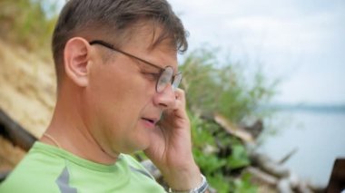 Denize sıfır plaj, telefonda konuşurken olgun iş adamı
