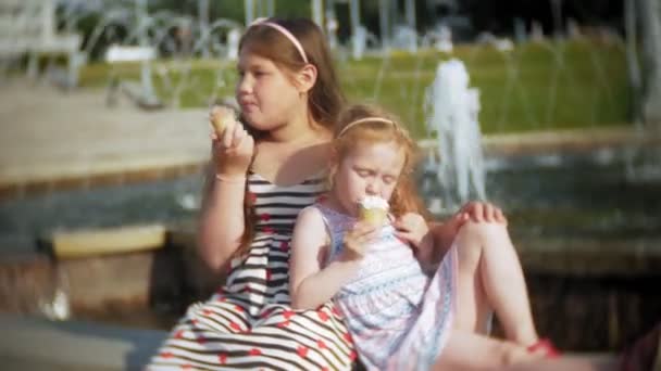 孩子, 小女孩吃冰淇淋在炎热, 炎热的夏日, 孩子们附近的喷泉 — 图库视频影像