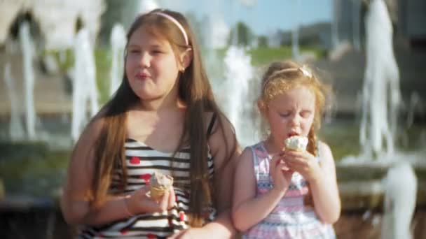 Παιδί, μικρό κορίτσι τρώει με παγωτό σε ένα ζεστό, καυστικός καλοκαιρινή μέρα, τα παιδιά κοντά το σιντριβάνι — Αρχείο Βίντεο
