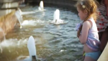 Çocuk, küçük kız yemek dondurma bir sıcak, kavurucu yaz günü, çocuk fountain yakınındaki