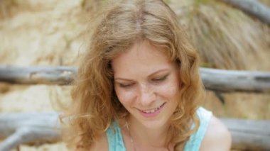 Cam şarap içme ve deniz kumlu plaj boyunca yürüyen genç güzel kadın