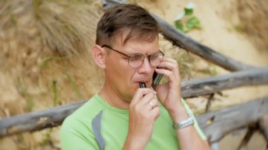 Denize sıfır plaj, telefonda konuşurken olgun iş adamı