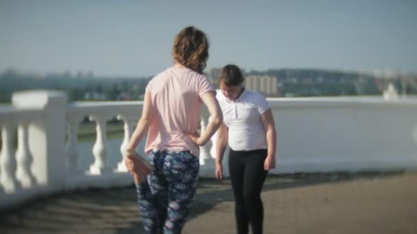 Tytöt ulkona tekemässä urheilu venyttely — kuvapankkivideo