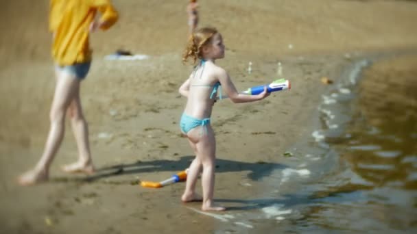 Женщина с девочкой, играющей в реке — стоковое видео