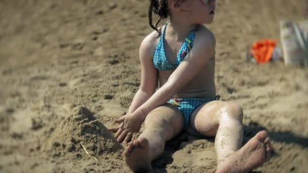 Menina brincando na praia com areia — Vídeo de Stock