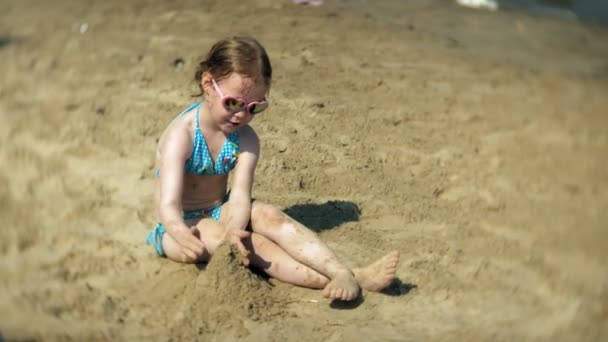 Niña jugando en la playa con arena — Vídeos de Stock