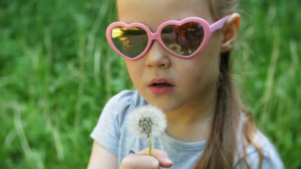 Nahaufnahme eines glücklichen kleinen Mädchens mit Löwenzahn im Park — Stockvideo