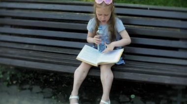 Gönüllülük a kitap, arka planını bir şehir parkı bir şehirde ahşap bir bankta oturan genç kız