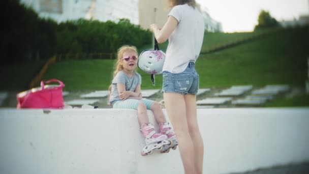 Máma a dcera jezdit na kolečkových bruslích. Dívka učí kolečkové brusle a vodopády. Máma učí dceru jezdit na válcích — Stock video