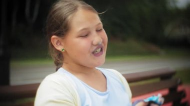 Sevimli küçük şişko kızın elleri parkta bir bankta oturmuş bir pasta yeme yakın çekim