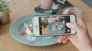 Kadın el yemek yiyecek yanında Smartphone fotoğrafını çekmek. Portre.