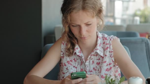 Hermosa mujer usando teléfono inteligente en la cafetería — Vídeo de stock