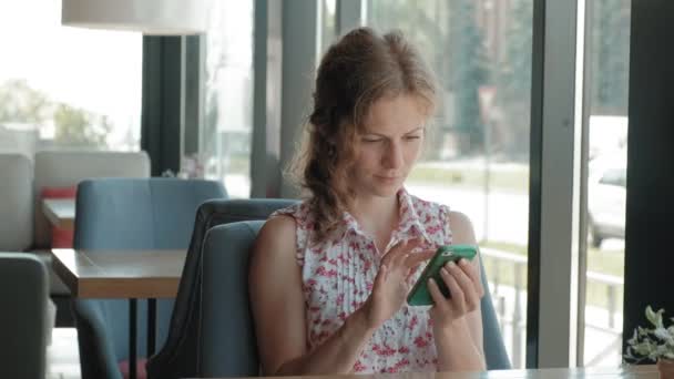 Schöne Frau mit Smartphone im Café — Stockvideo