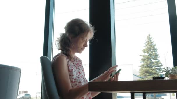 Krásná žena pomocí smartphone v kavárně — Stock video