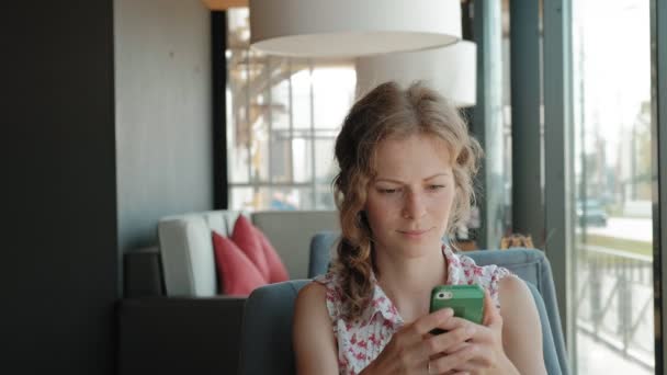 Schöne Frau mit Smartphone im Café — Stockvideo