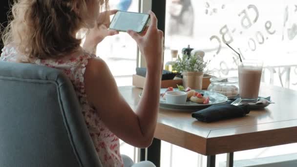 Ung kvinna äta dessert på en restaurang — Stockvideo