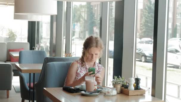 Ung kvinna äta dessert på en restaurang — Stockvideo