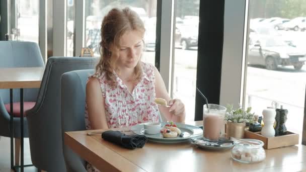 Jeune femme mangeant un dessert dans un restaurant — Video