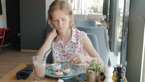 Mujer joven comiendo postre en un restaurante — Vídeo de stock