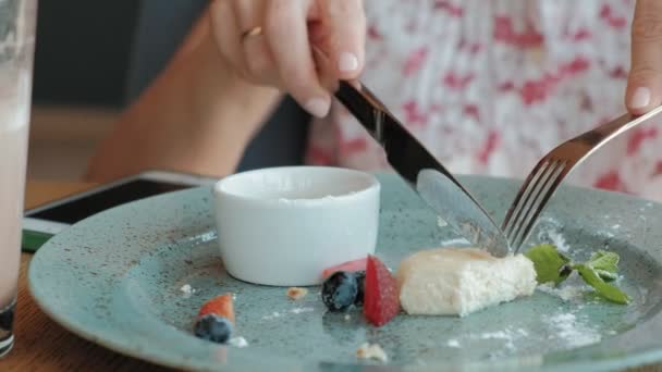 Молода жінка їсть десерт у ресторані — стокове відео