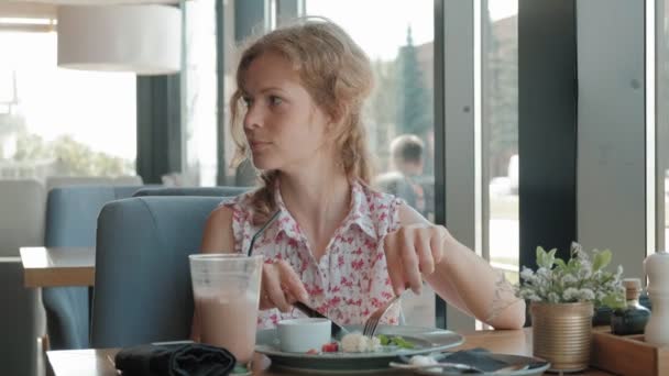 Jeune femme mangeant un dessert dans un restaurant — Video