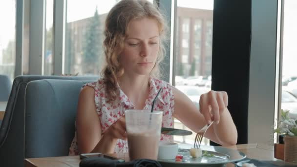 Mujer joven comiendo postre en un restaurante — Vídeos de Stock