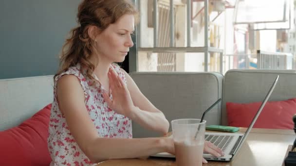 Fiatal üzleti nő ül egy asztalnál egy étteremben. Ő végzett egy laptop kapcsolódik az internethez, ellenőrzi a leveleket. Úgy néz ki, nagyon boldog — Stock videók