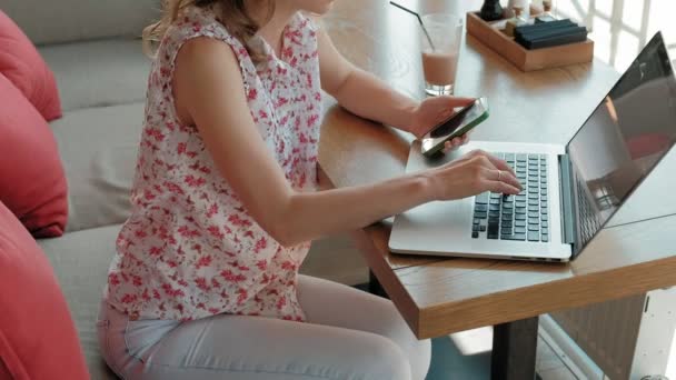 Fiatal üzleti nő ül egy asztalnál egy étteremben. Ő végzett egy laptop kapcsolódik az internethez, ellenőrzi a leveleket. Úgy néz ki, nagyon boldog